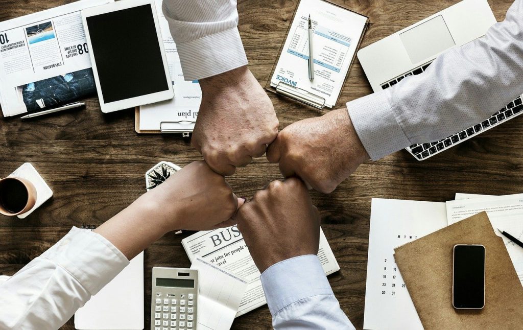 new business formation, business partners giving fistpunch over desk