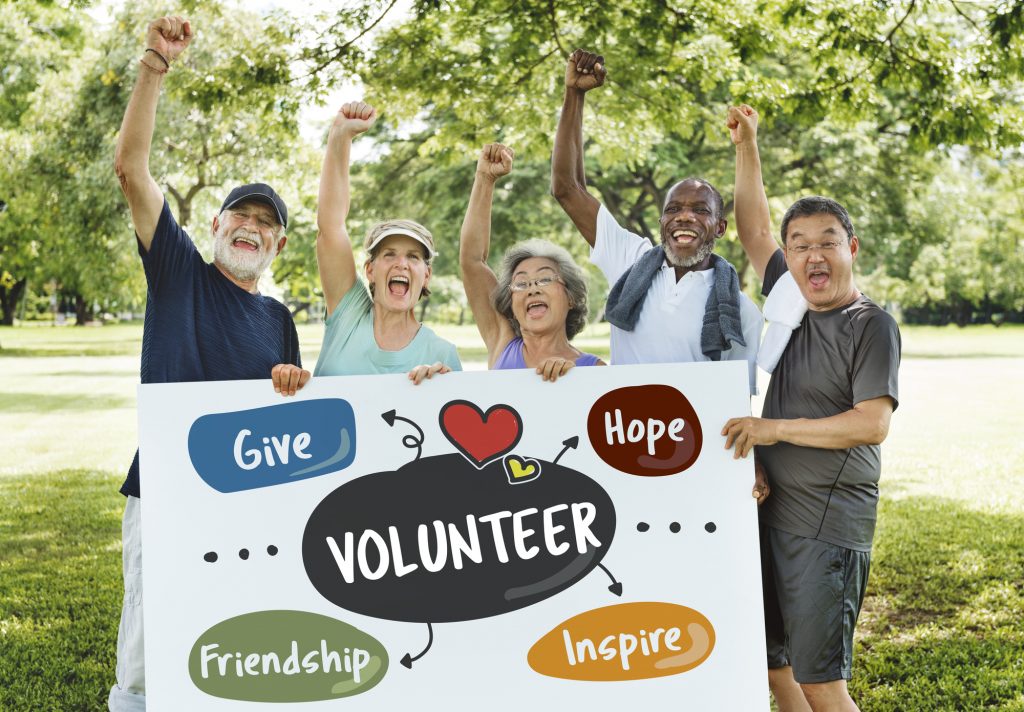 group of older people holding a sign readying volunteer give and hope, non-profit organization tax services, Donations Charity Volunteer Words Concept